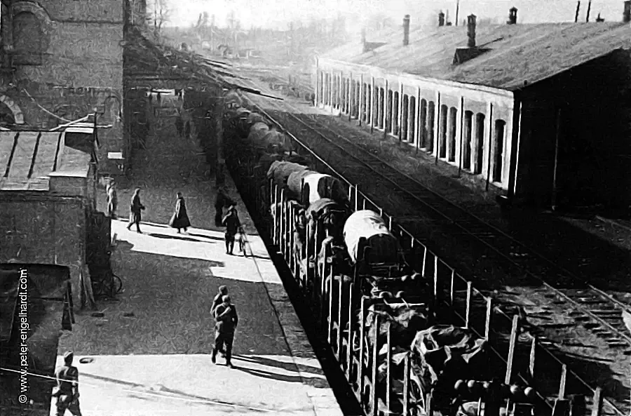 Blick von erhöhter Position auf einen mit Militärfuhrwerken beladenen offenen Güterzug im Bahnhof Ljuban August 1942.