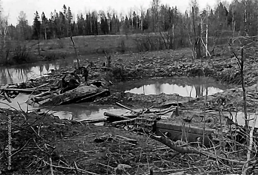 Two Russian tanks destroyed by Stukas are half-submerged in muddy bomb craters along the Volkhov.