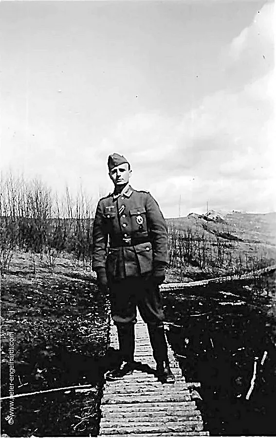 März 1943 Unteroffizier Menge steht auf einem mit Holz befestigten Weg im Stützpunkt.